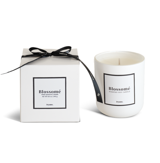 Candle with packaging labeled 'Blossomé' on a white background