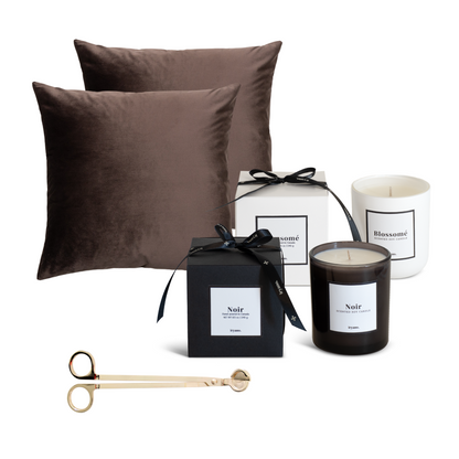 Brown pillows, black and white boxes, and candles on a white background