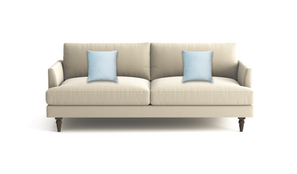 A modern two-seater sofa in a light beige fabric, styled with two light blue throw pillows and supported by dark brown wooden legs, shown against a plain white background.