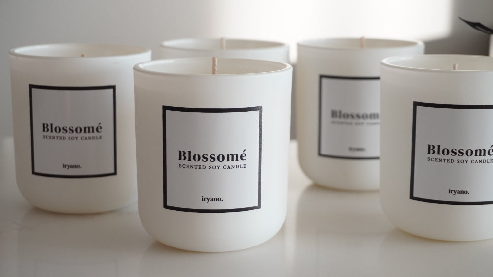 White candles with 'Blossomé' labels on a light background