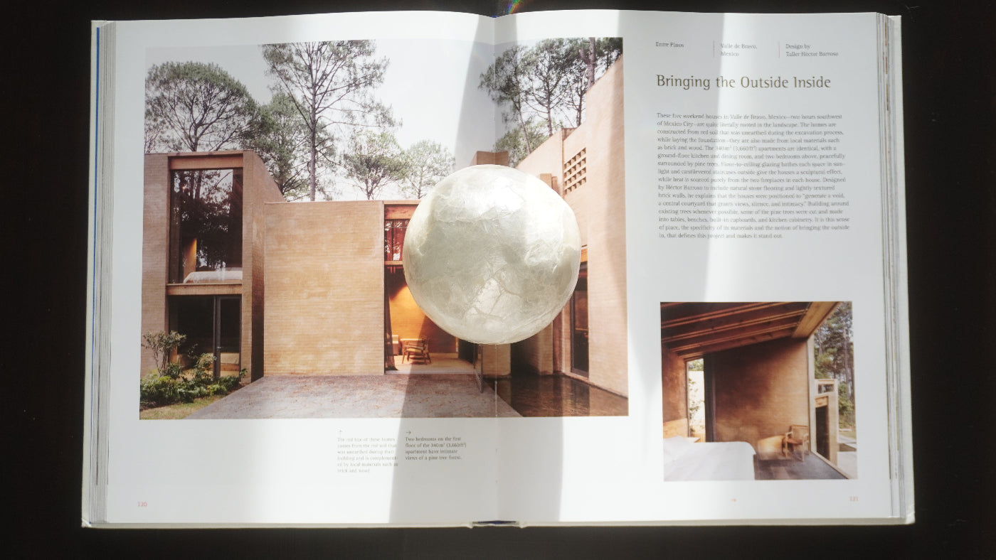 Open book showing interior design with a modern house and spherical object.