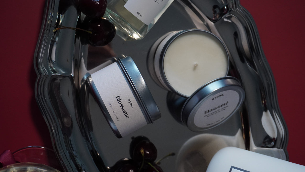 Bath and body products including candles and soaps on a tray with a red background