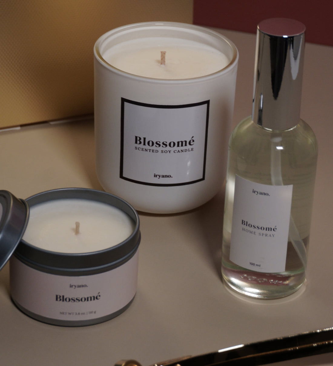 Two candles and a bottle of wine on a surface with a blurred background