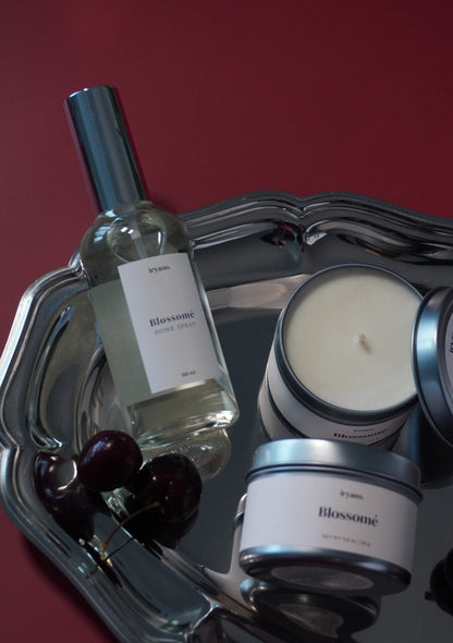 Bottle of wine and two candles on a decorative stand with a red background