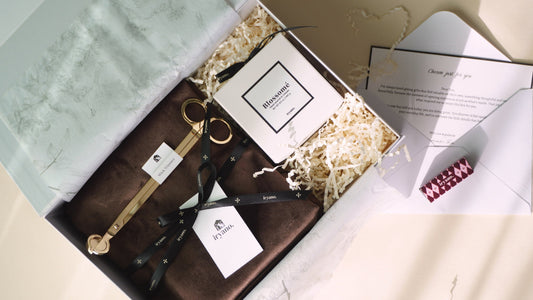 Gift box with stationery items on a light surface