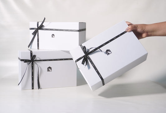White gift boxes with black ribbons on a white background