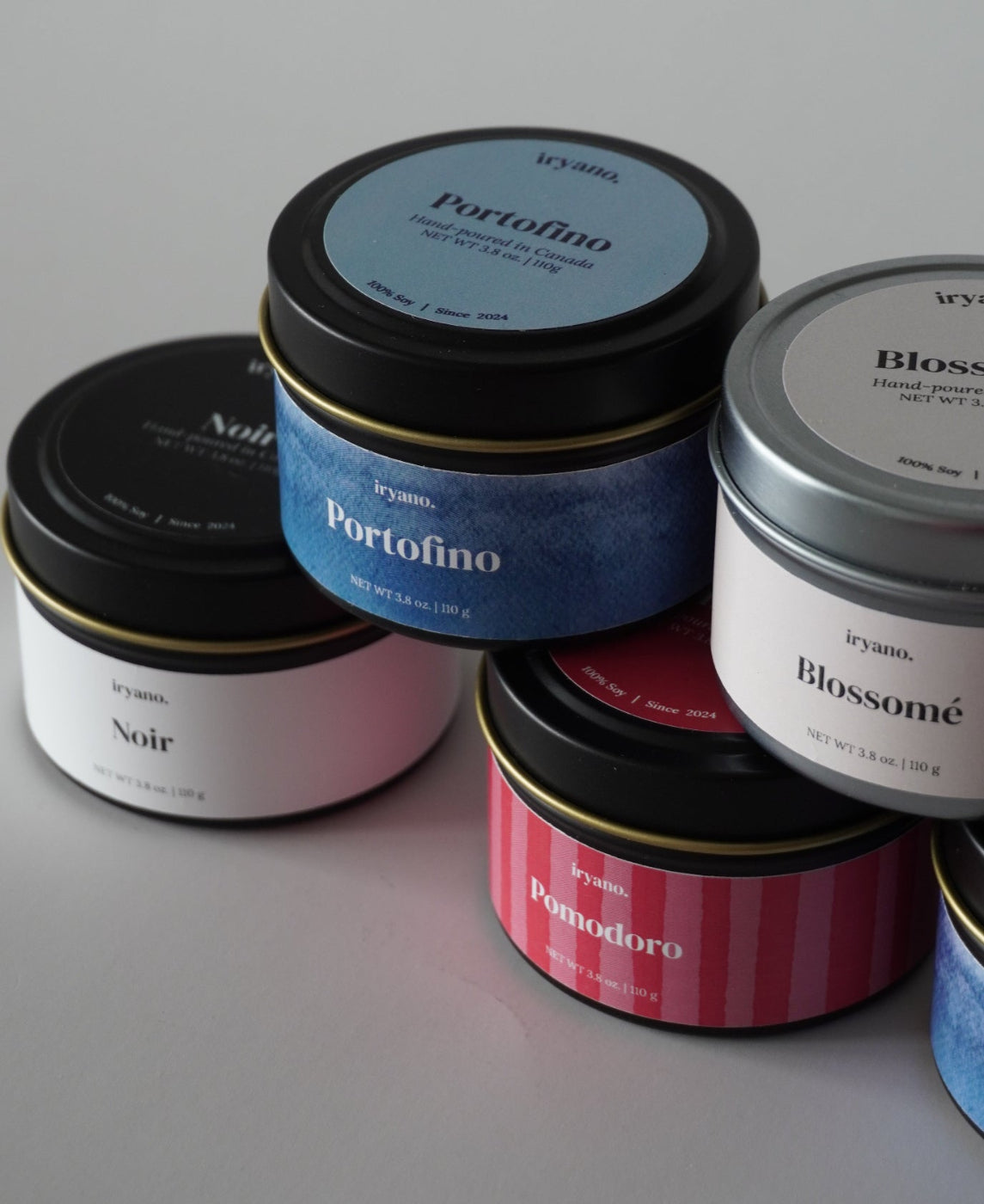 Collection of small cylindrical containers with labels on a light gray background