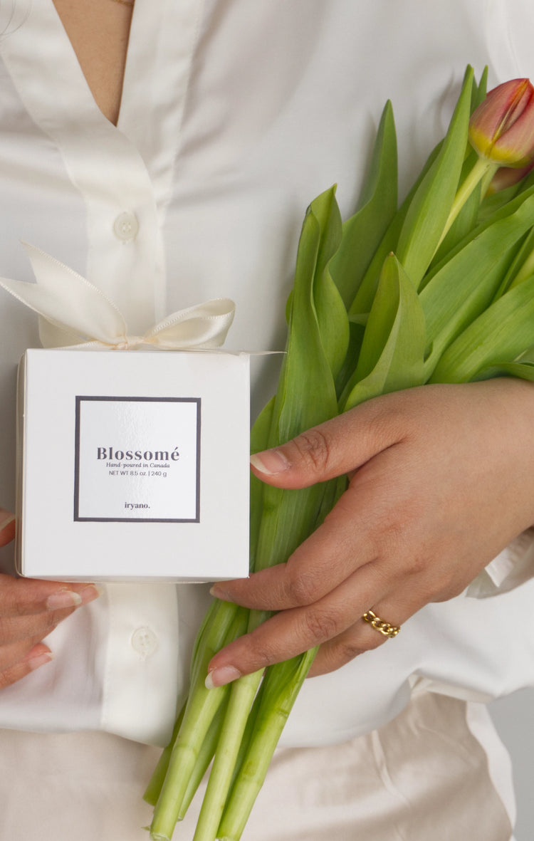 Person holding a box labeled 'Blossomi' and a bouquet of tulips.