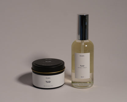 Candle and perfume bottle with 'Nude' label on a gray background