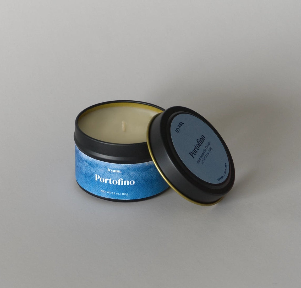 Candle in a tin with 'Portofino' label on a gray background